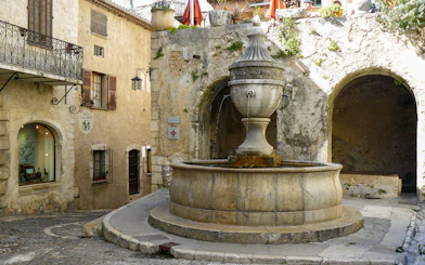 Stone fountain in a quaint street of a Provence village, France.
