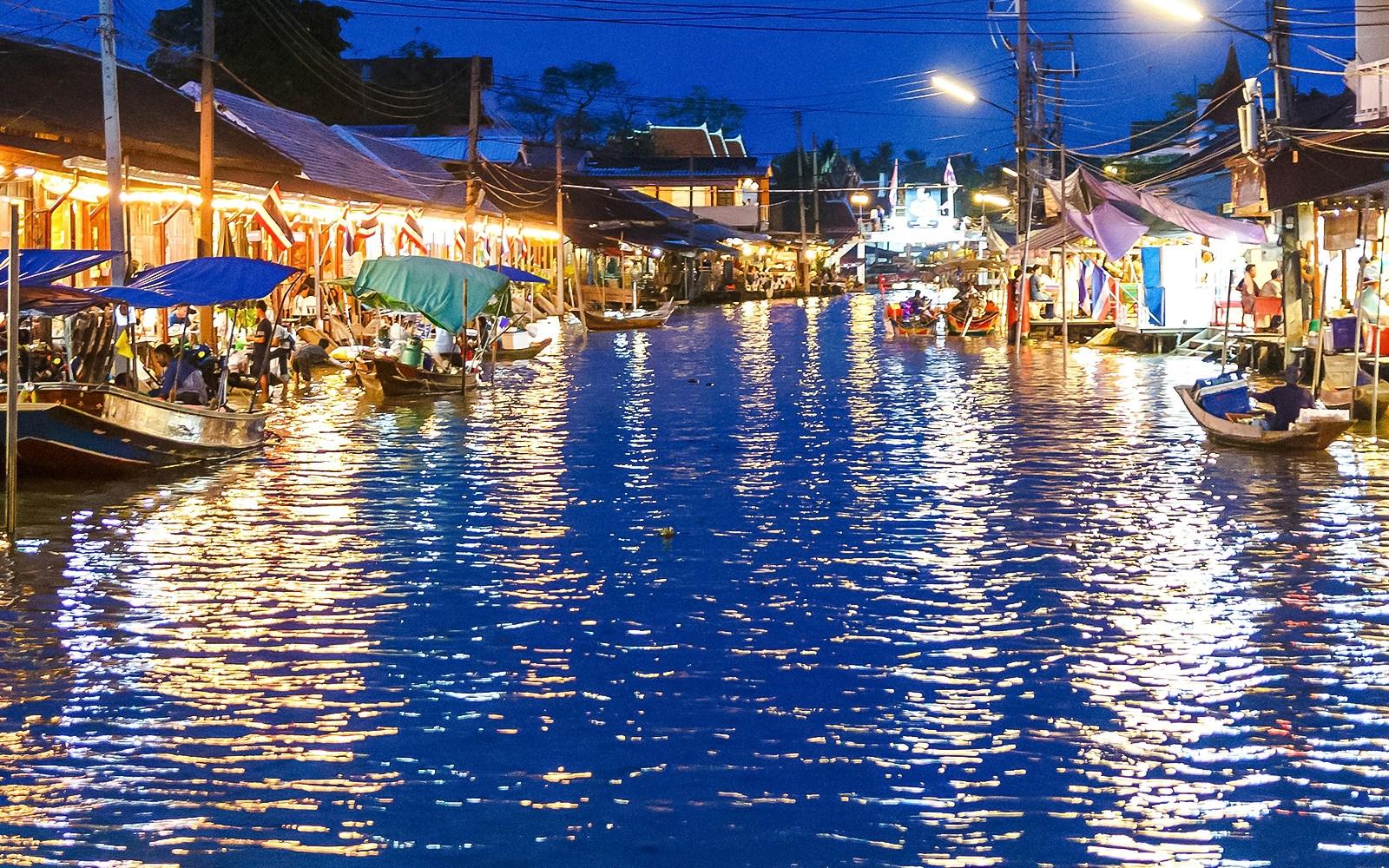 night view of boats with tourists at floating market
