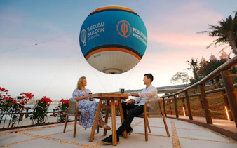 Couple enjoying a drink under The Dubai Balloon at Atlantis, Dubai.