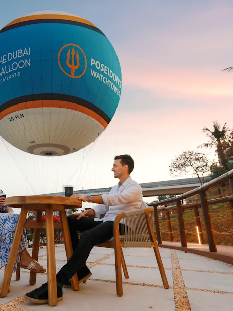 Couple enjoying a drink under The Dubai Balloon at Atlantis, Dubai.