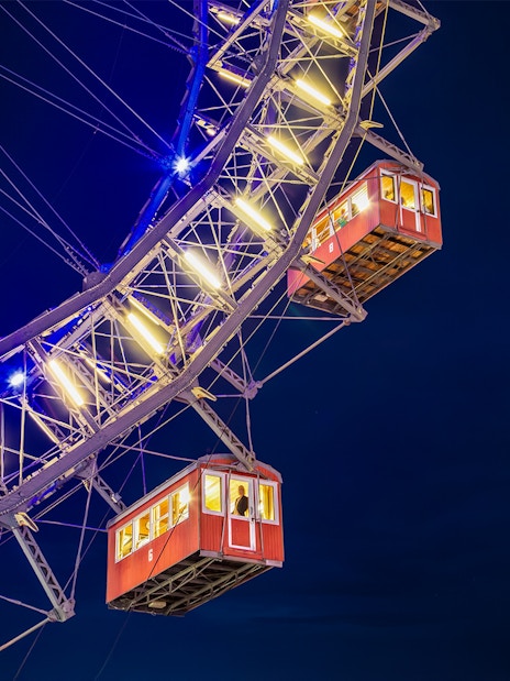 Cabins of the Giant Ferris Wheel in Vienna illuminated at night.