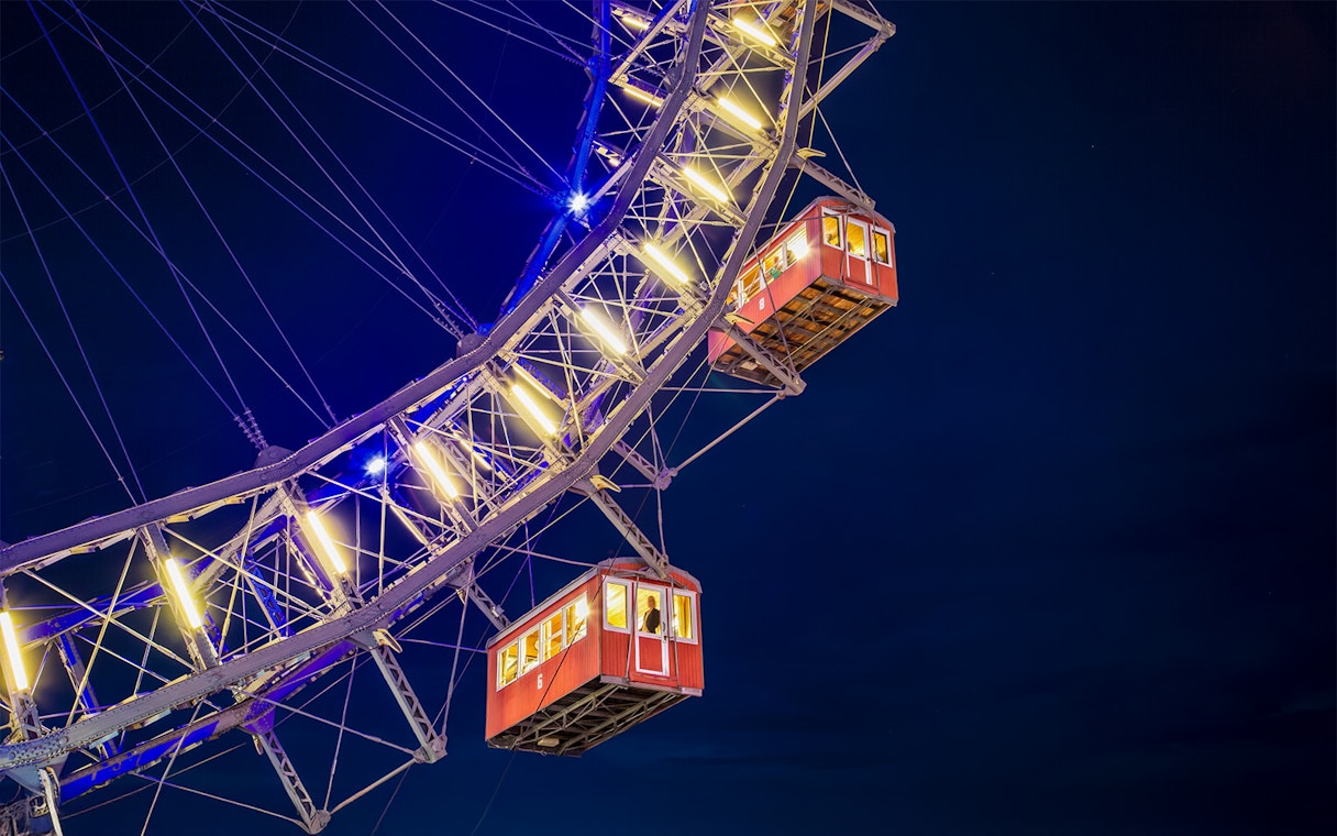 Cabins of the Giant Ferris Wheel in Vienna illuminated at night.