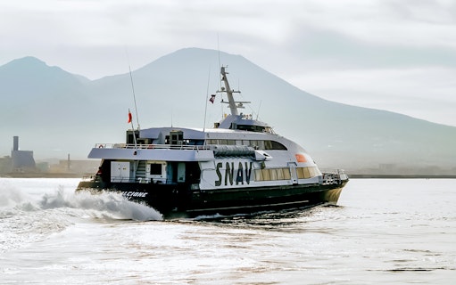 SNAV ferry sailing from Naples to Ischia with Mount Vesuvius in the background.