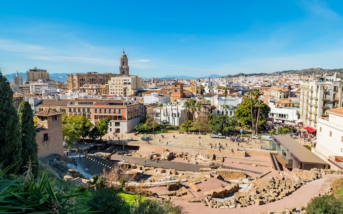 Roman Theatre ruins with Malaga cityscape near Picasso Museum.