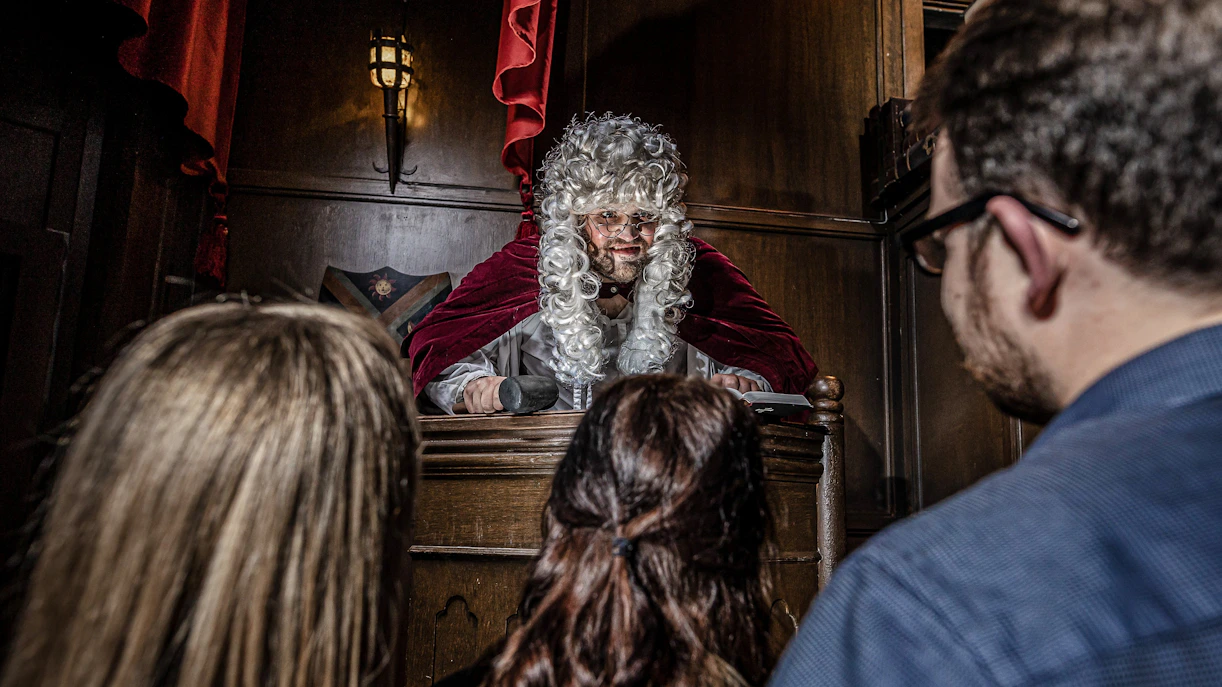 Judge in period costume presiding over courtroom scene at York Dungeon.