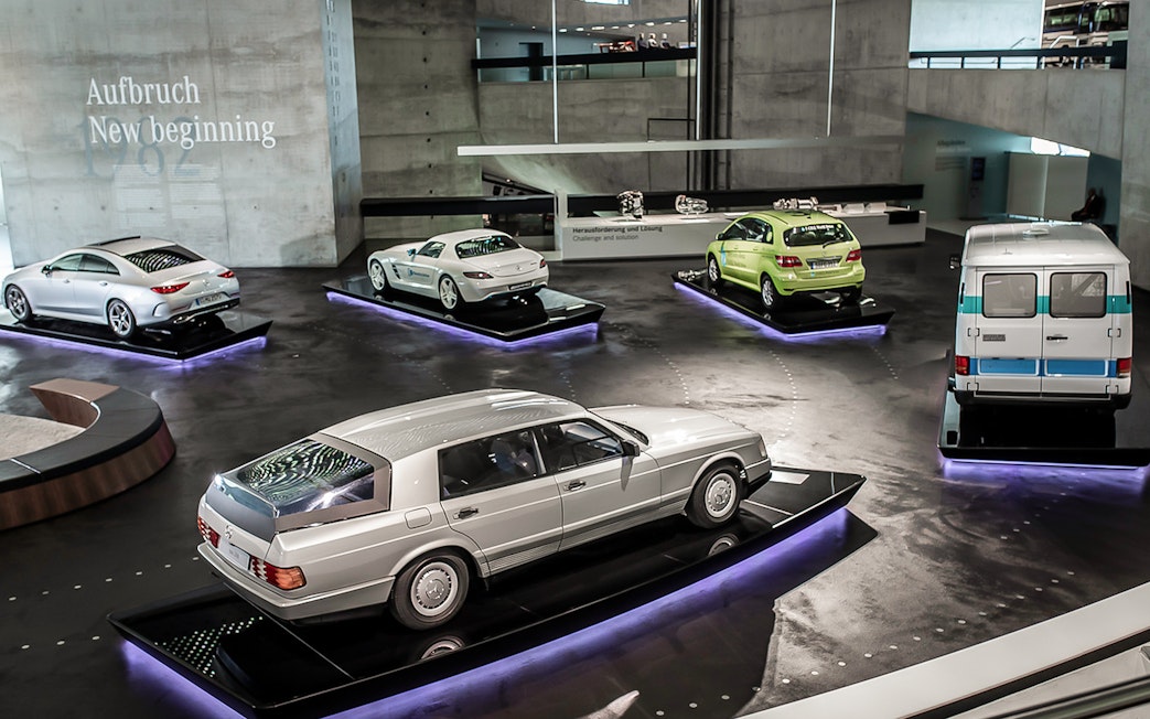 Mercedes Benz Museum exhibit featuring classic and modern cars on display platforms.