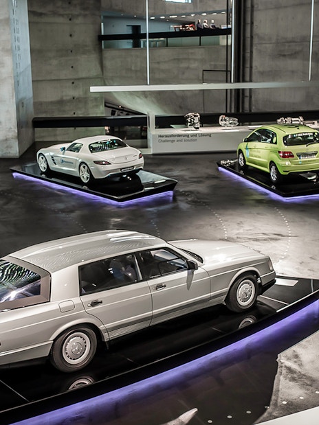Mercedes Benz Museum exhibit featuring classic and modern cars on display platforms.