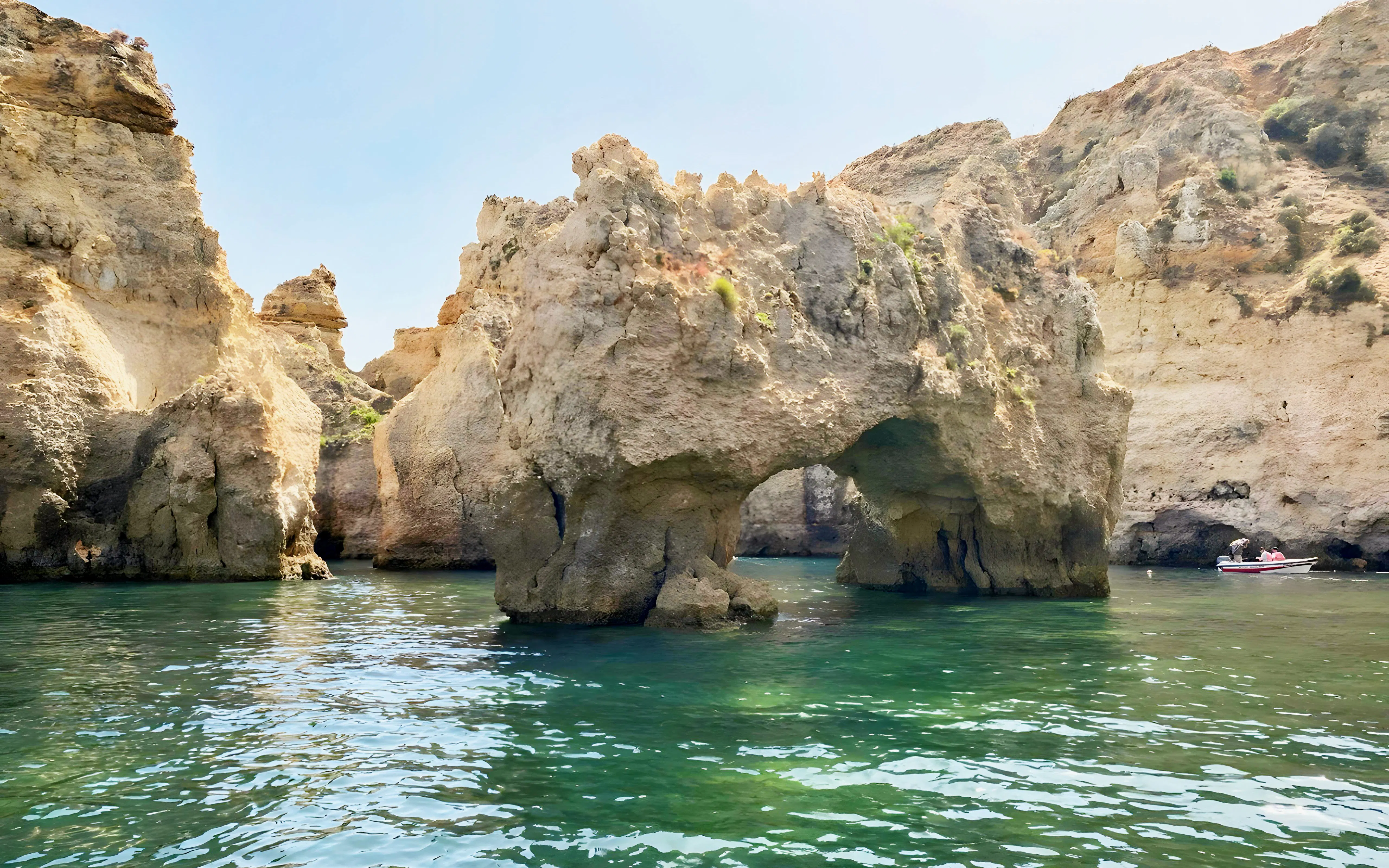 Ponta da Piedade rock formations with a boat on the water, Lagos, Portugal.