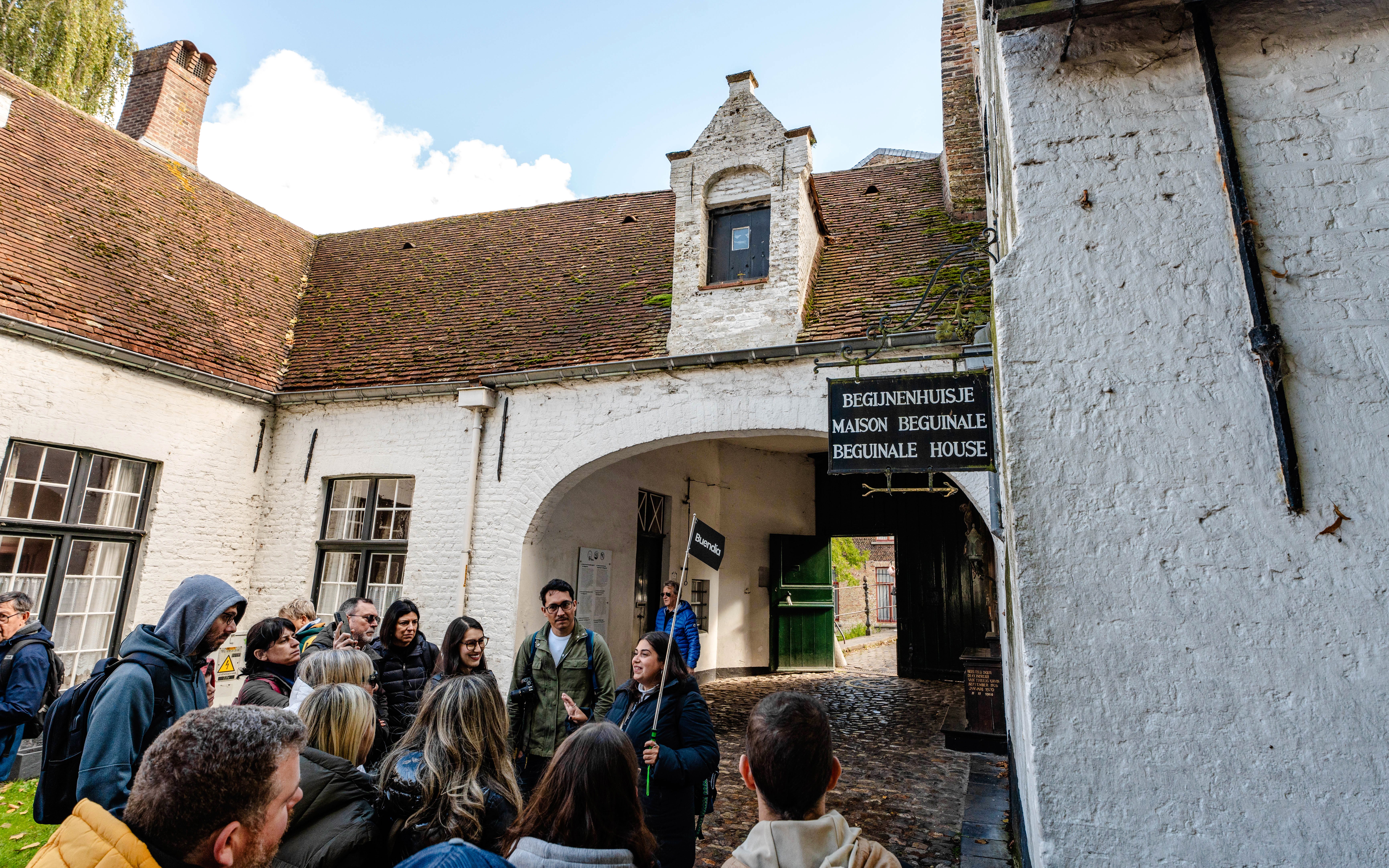 Group on a guided tour at Princely Beguinage Ten Wijngaarde, Bruges, Belgium.