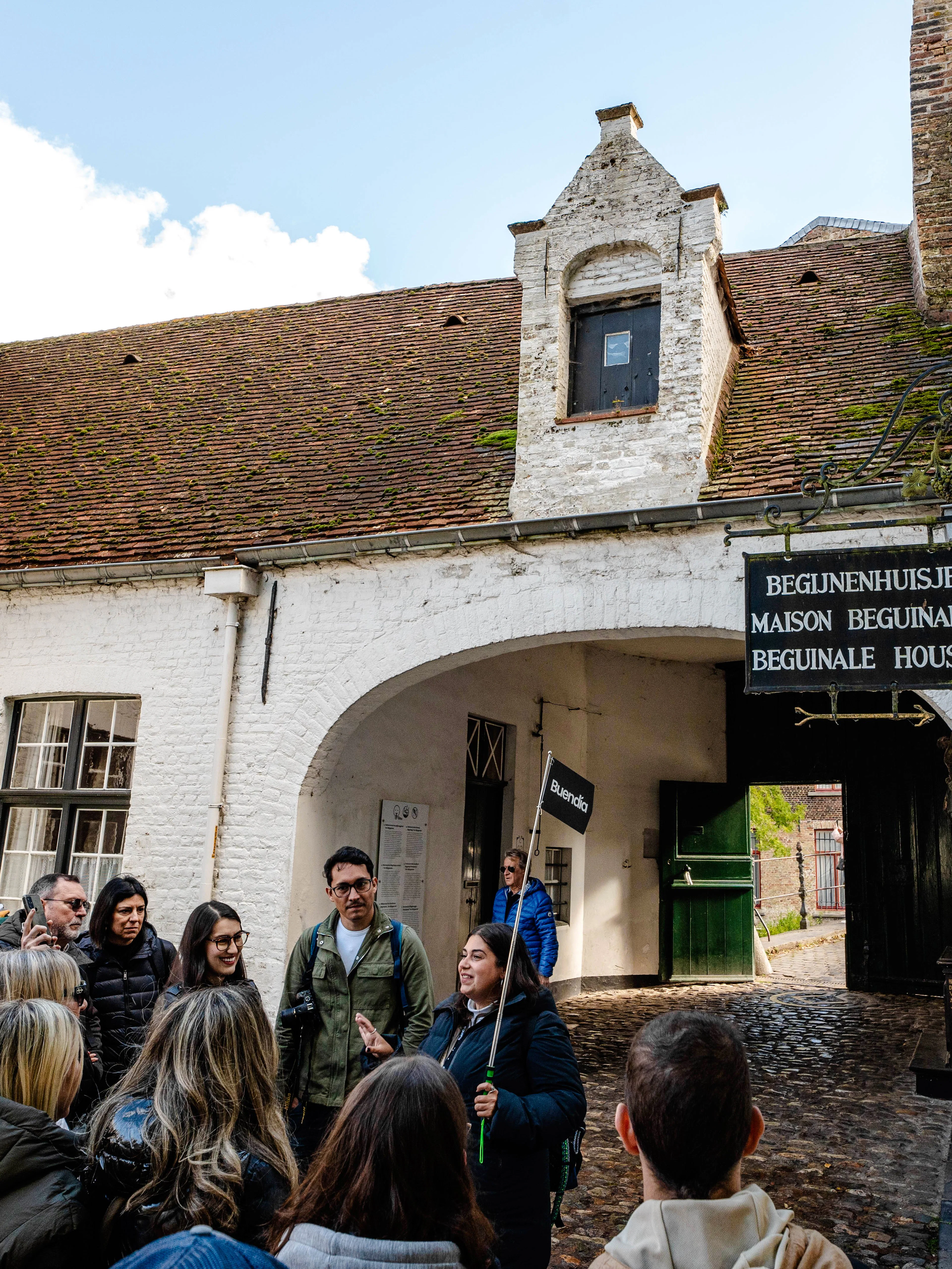Group on a guided tour at Princely Beguinage Ten Wijngaarde, Bruges, Belgium.