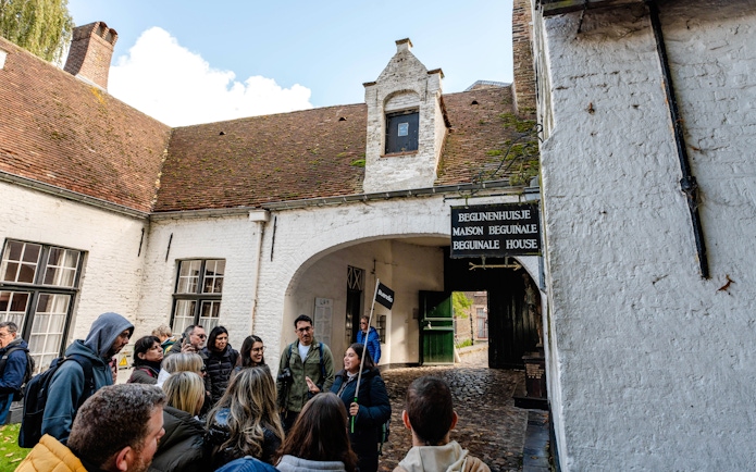 Group on a guided tour at Princely Beguinage Ten Wijngaarde, Bruges, Belgium.