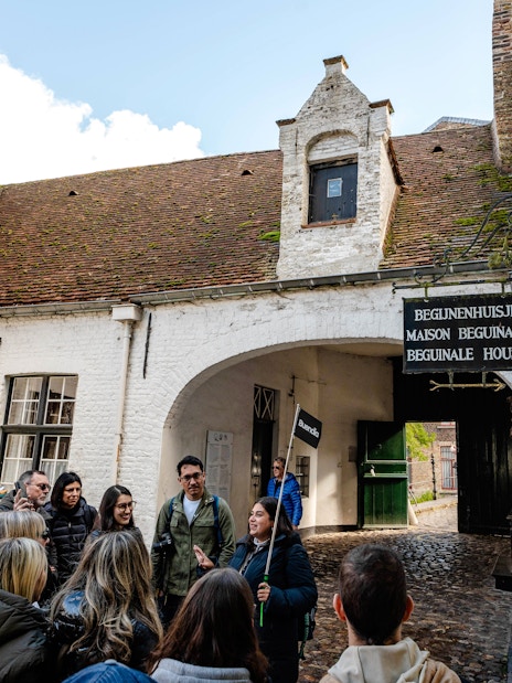 Group on a guided tour at Princely Beguinage Ten Wijngaarde, Bruges, Belgium.