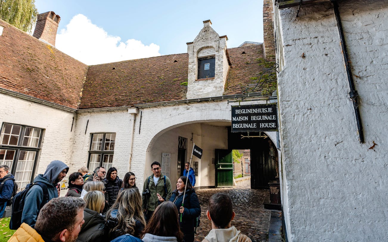 Group on a guided tour at Princely Beguinage Ten Wijngaarde, Bruges, Belgium.