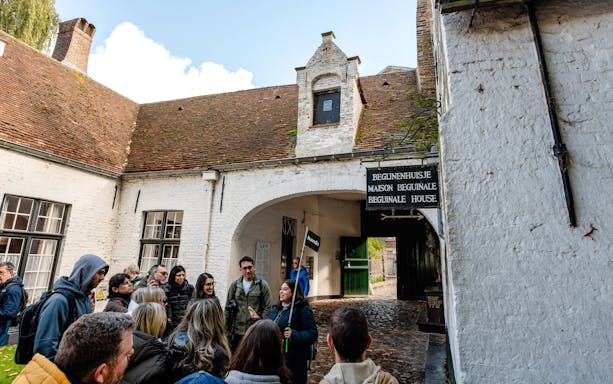 Group on a guided tour at Princely Beguinage Ten Wijngaarde, Bruges, Belgium.