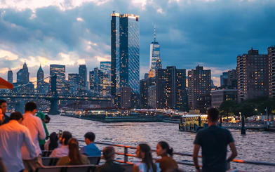 New York City skyline at night with people on a boat tour.