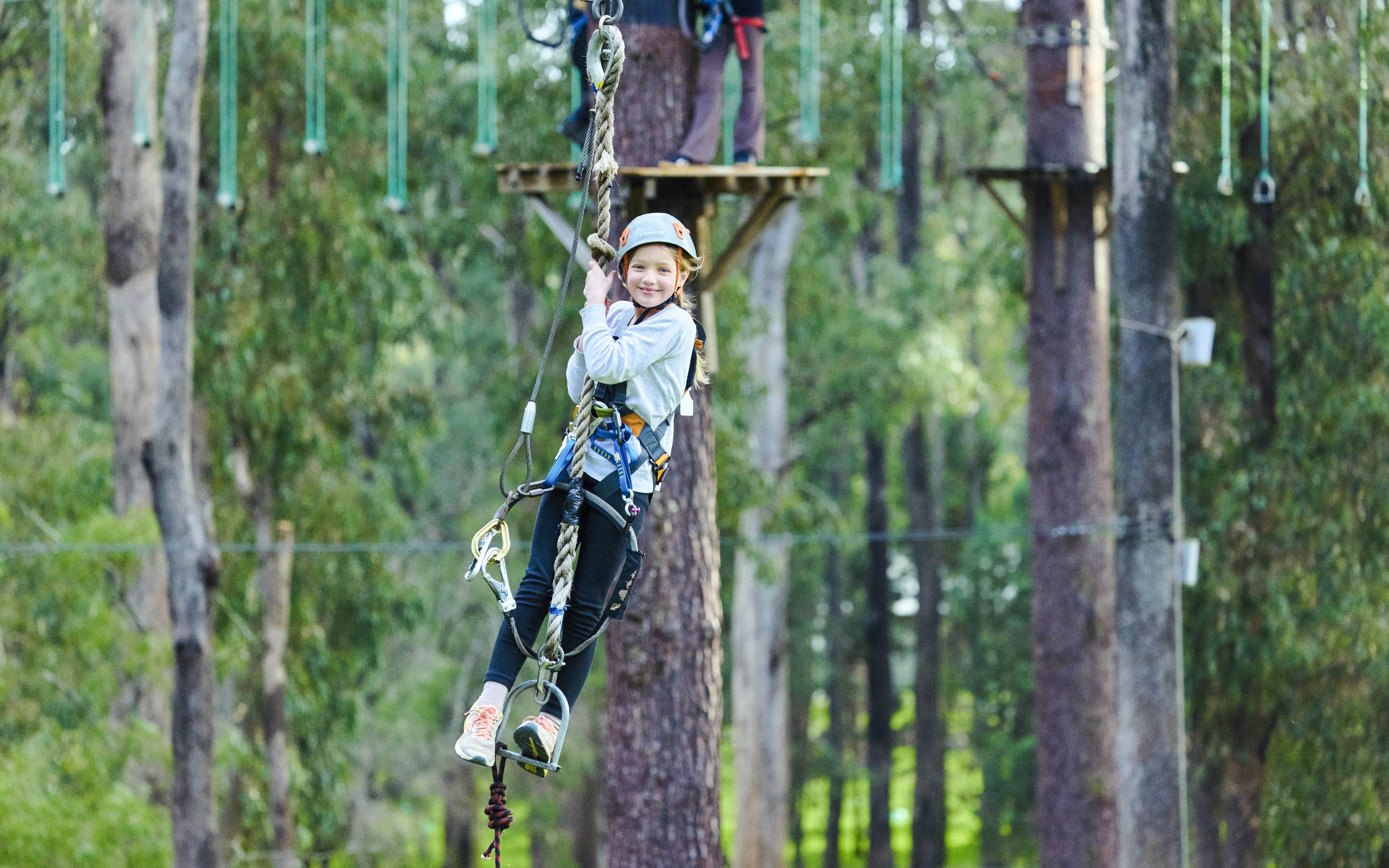 Child on high ropes course in Busselton forest adventure park.
