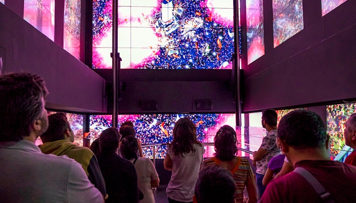 Visitors in Benfica Stadium museum's virtual lift viewing digital display.