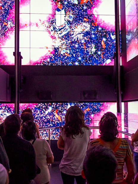 Visitors in Benfica Stadium museum's virtual lift viewing digital display.