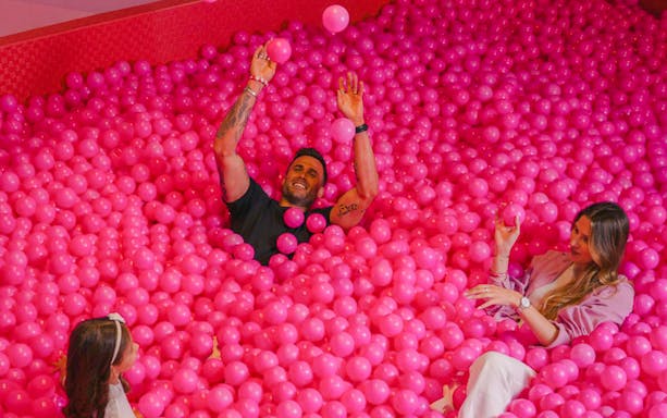 Visitors enjoying a pink ball pit at the Pink Palace in the WOW cultural district.