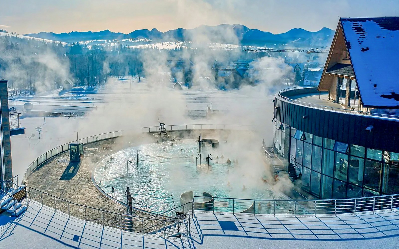 Thermal pools with steam rising, surrounded by snow, in Zakopane.
