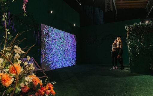 Visitors enjoying Monet's Garden immersive exhibition in Vienna with vibrant digital art display.