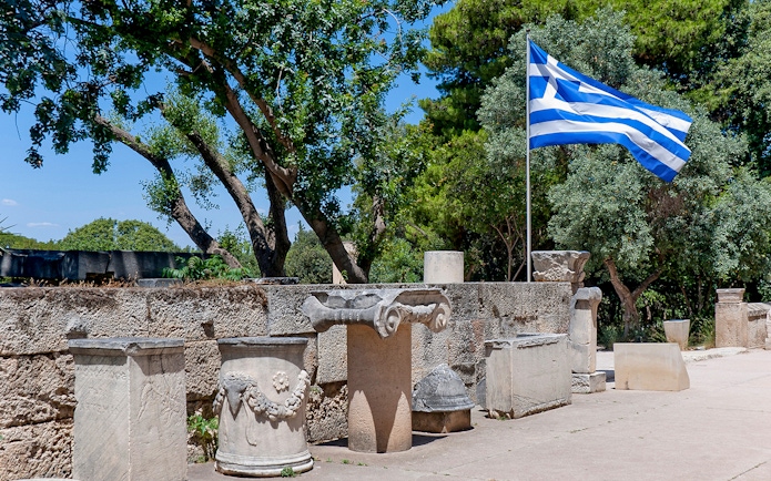 Ancient ruins and Greek flag at Athens Ancient Agora.