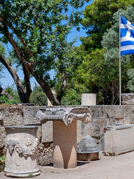 Ancient ruins and Greek flag at Athens Ancient Agora.