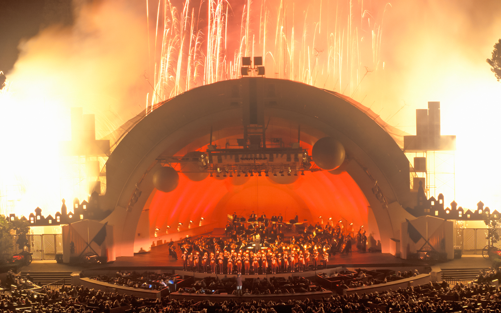 Concert at Hollywood Bowl amphitheatre with fireworks at sunset.