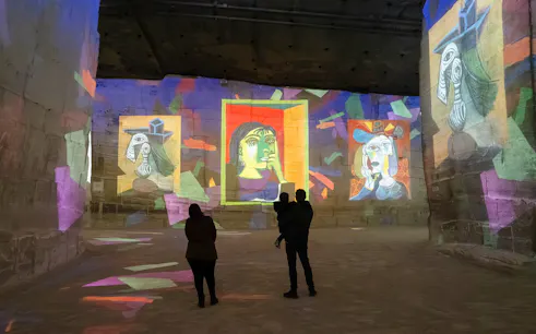 Picasso artworks projected on walls at Carrières des Lumières exhibit.