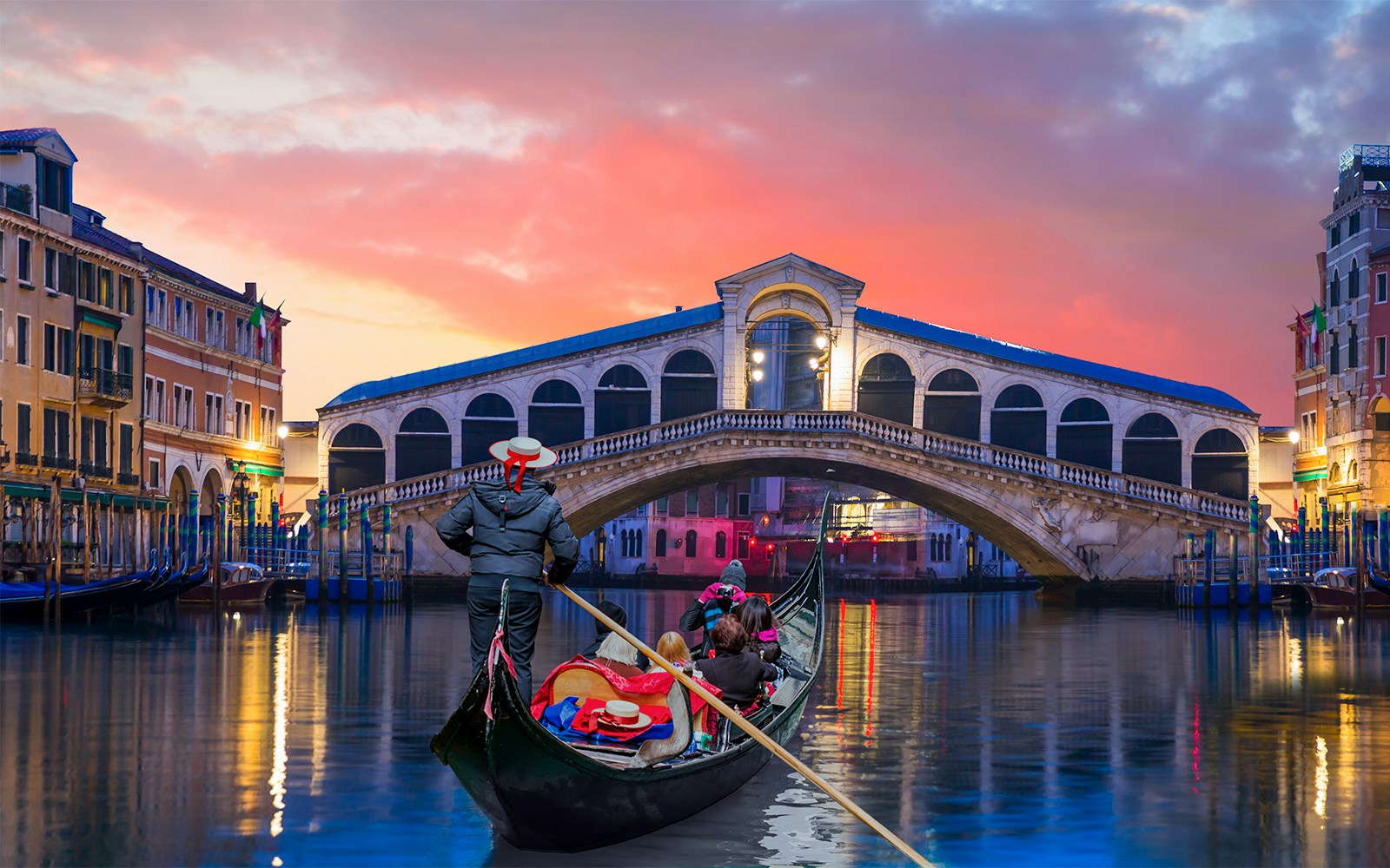 Gondola ride at sunset near Rialto Bridge, Venice.