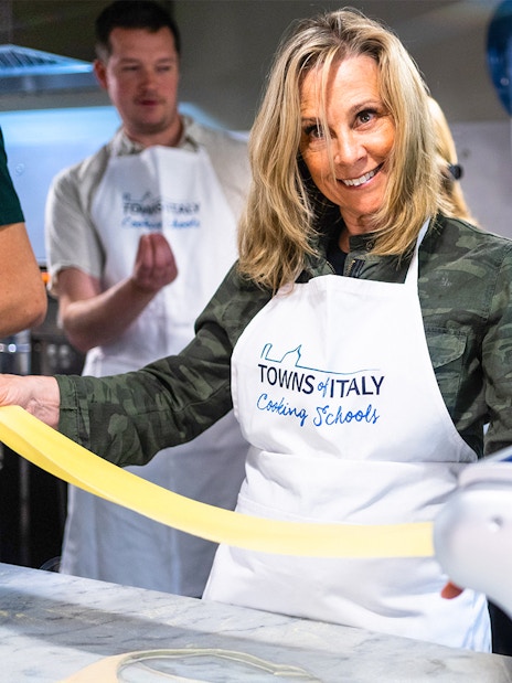 Pasta making class participant using a pasta machine in Florence, Italy.
