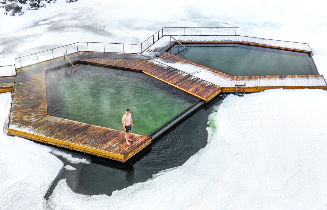 Vok Baths geothermal pools in Iceland surrounded by serene lake and lush landscape.