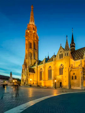 Matthias Church illuminated at dusk in Budapest, Hungary.