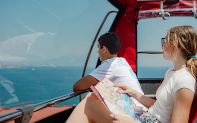 Passengers enjoying sea views on Naples hop-on hop-off bus tour.