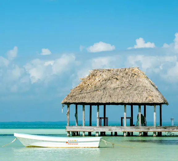 Boat near a thatched-roof pier on Isla Holbox, Mexico.