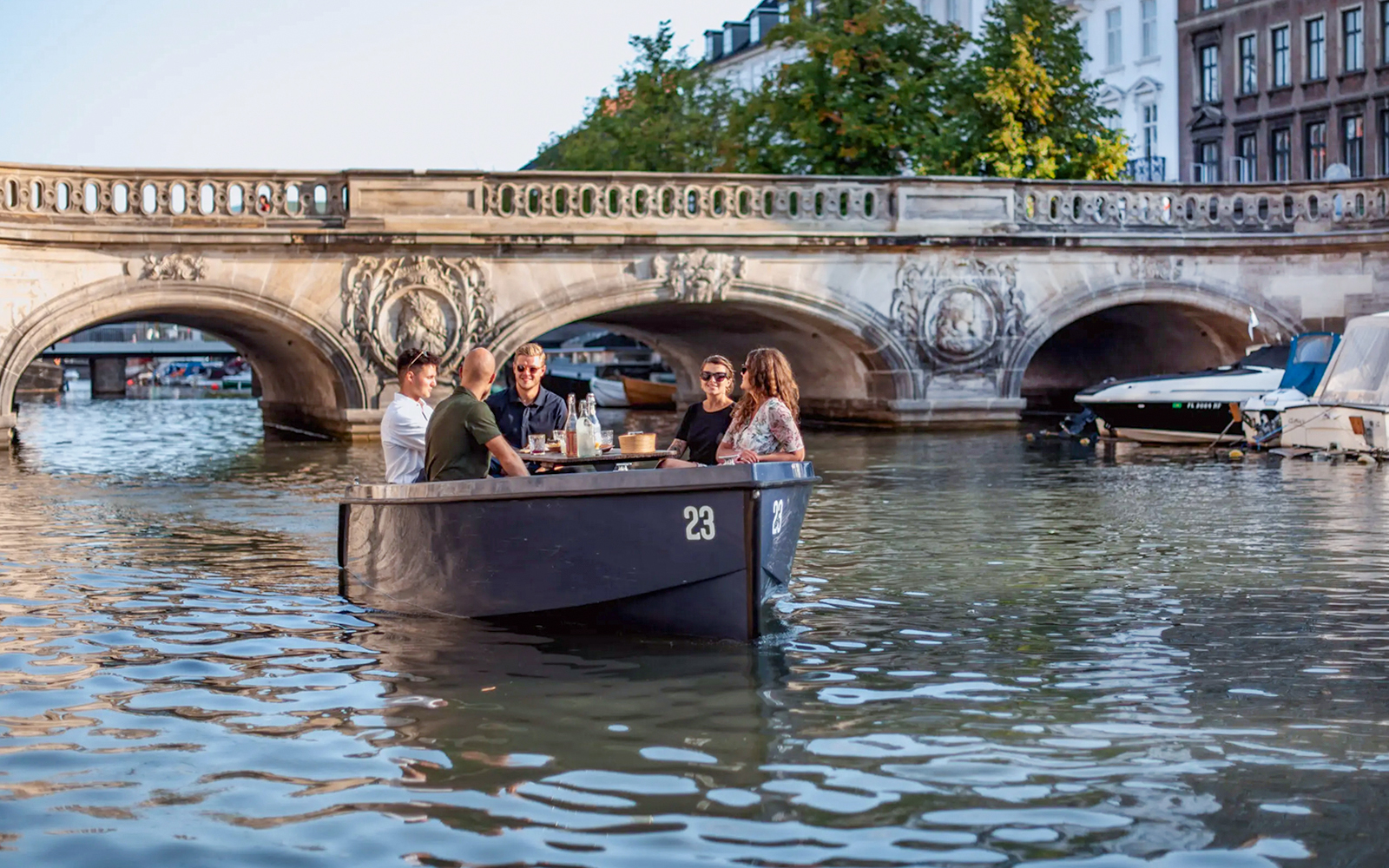 Friends on a GoBoat tour under a bridge in Copenhagen Harbour.