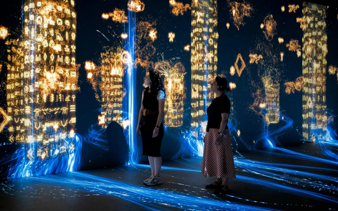 Visitors exploring digital hieroglyphs at Immerse LDN: Timewalk Exhibition.