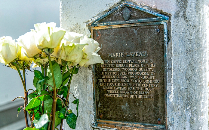 Tomb of Marie Laveau with white roses in St. Louis Cemetery, New Orleans.