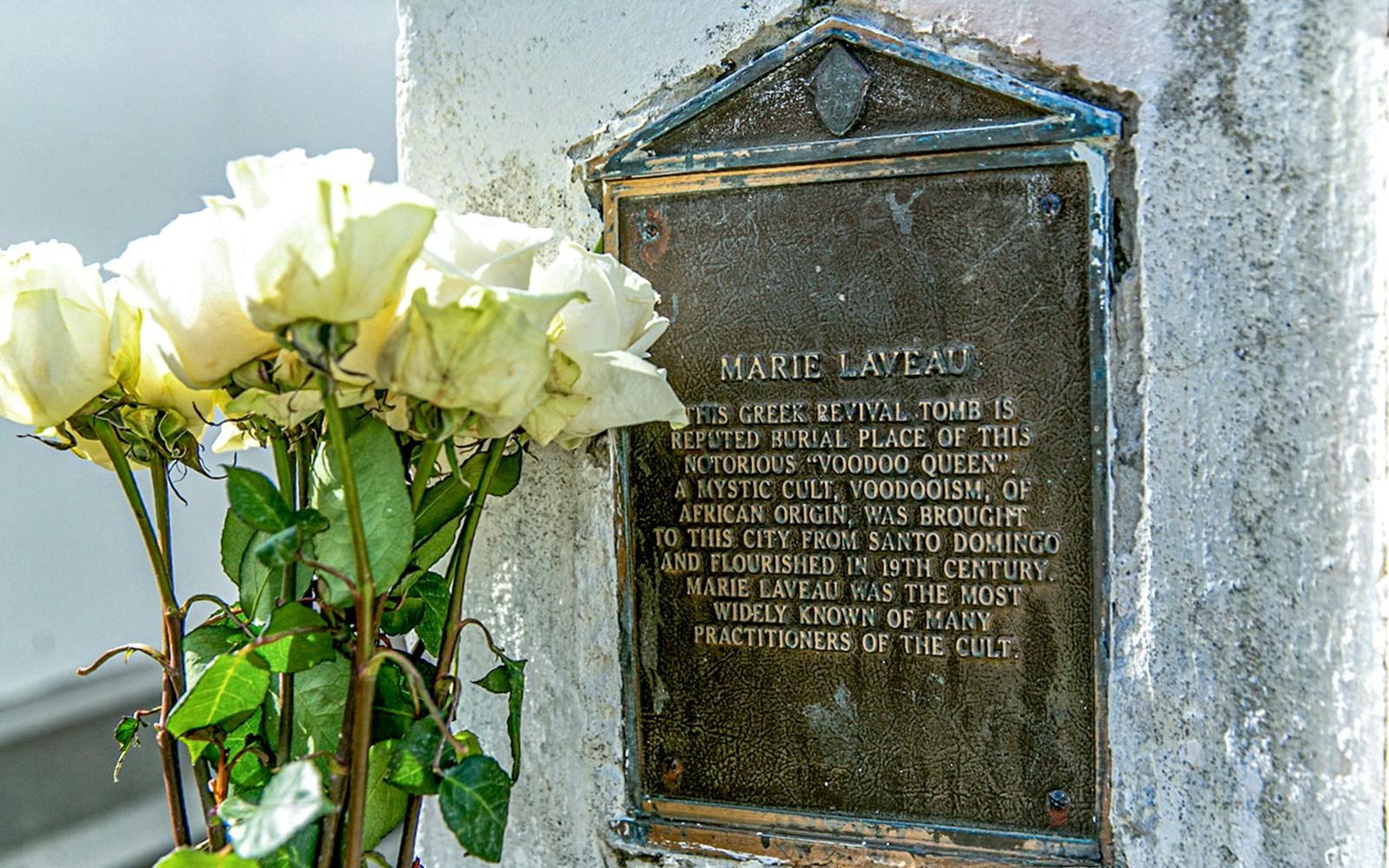 Tomb of Marie Laveau with white roses in St. Louis Cemetery, New Orleans.