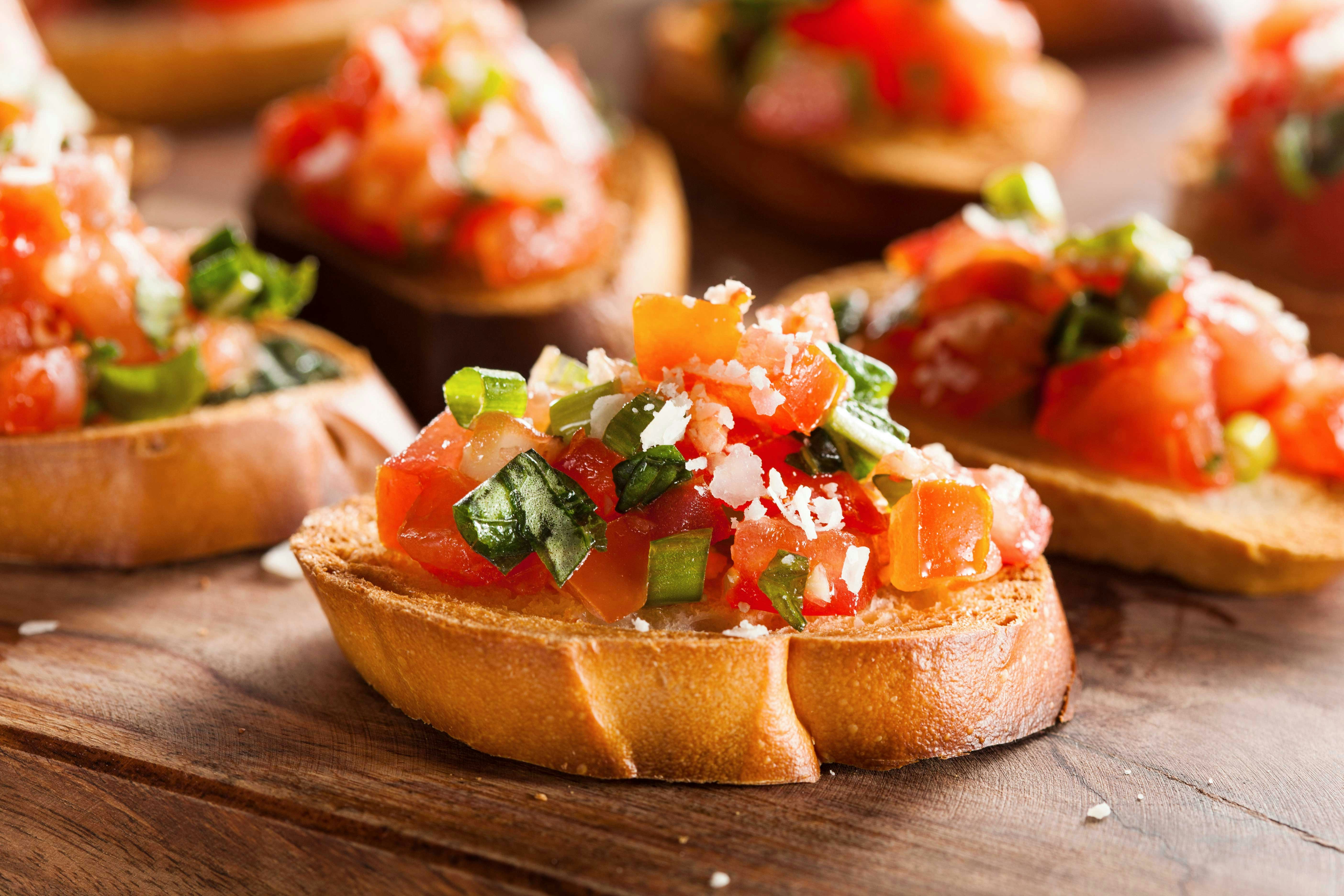 Bruschetta with tomatoes and basil on a wooden board in Rome, Italy.