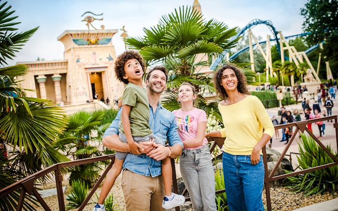 Family enjoying a day at Parc Asterix with Egyptian-themed attractions in the background.
