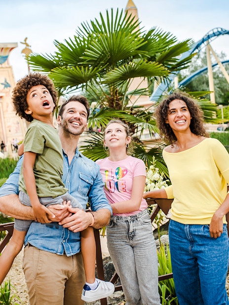 Family enjoying a day at Parc Asterix with Egyptian-themed attractions in the background.