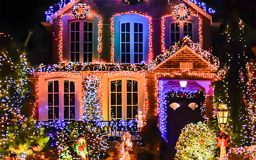Holiday lights decorating a house in New York, featuring colorful displays and festive wreaths.