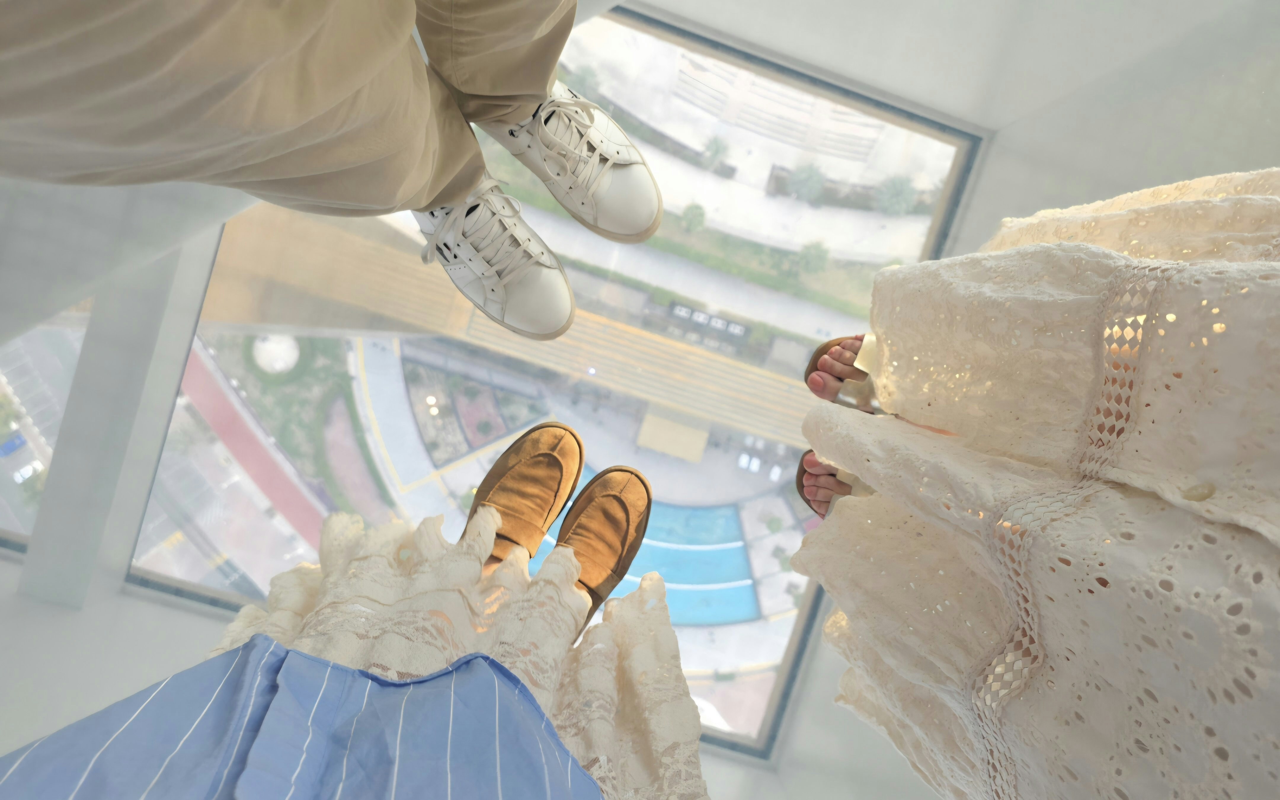 crouch low for a shot looking straight down at the city beneath your feet, or capture a wide-angle frame. Early morning light keeps the glass clear and minimises reflections.