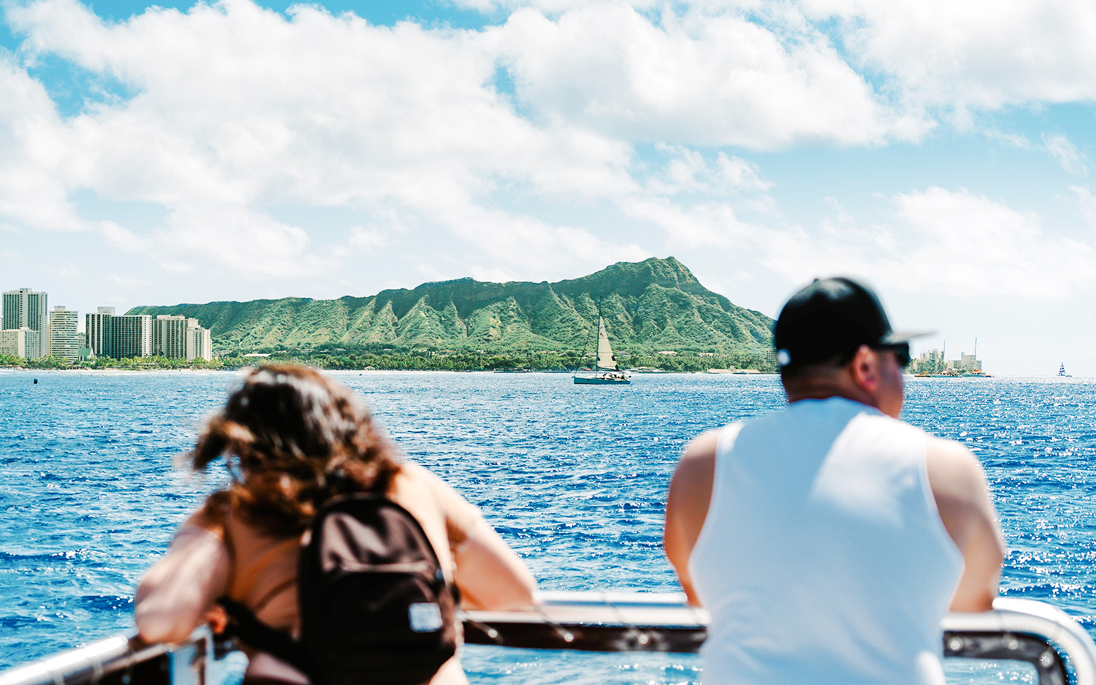 Glass-bottom boat view of Diamond Head, Oahu, Hawaii, with tourists observing the coastline.