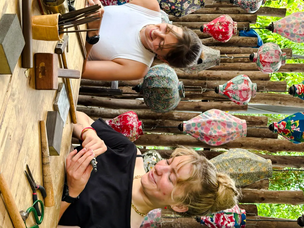 Creating jewelry at a workshop in Hoi An, surrounded by colorful lanterns.