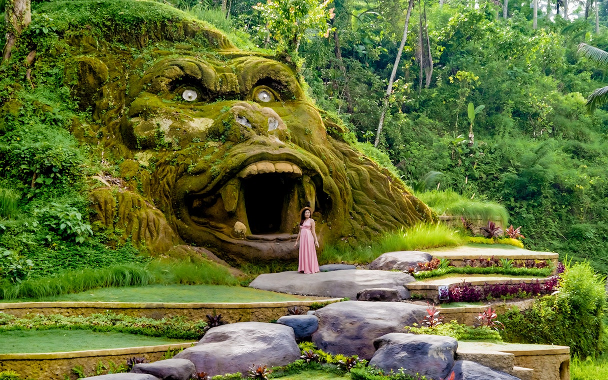 Lady standing near gorilla cave entrance at Alas Harum, Bali.