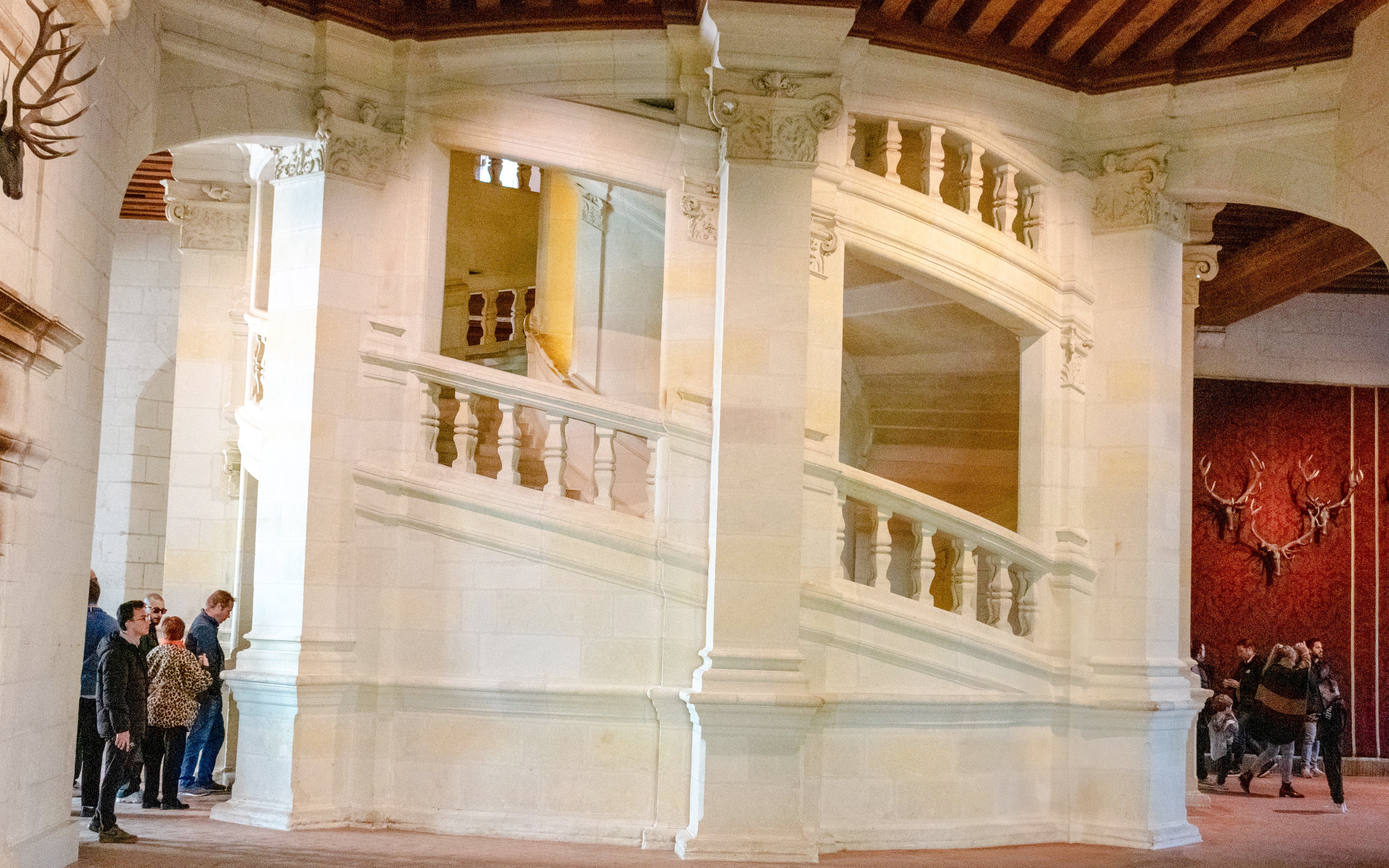 Chambord Castle's double helix staircase with visitors exploring.