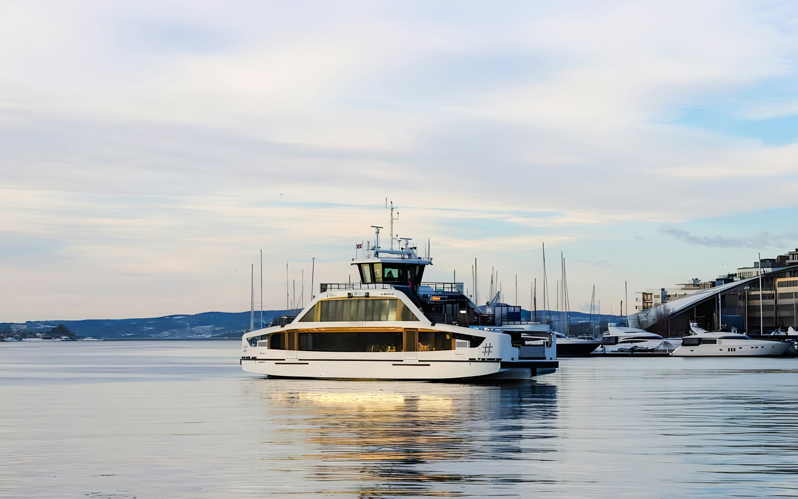 Oslo Fjord cruise boat navigating calm waters with cityscape in the background.