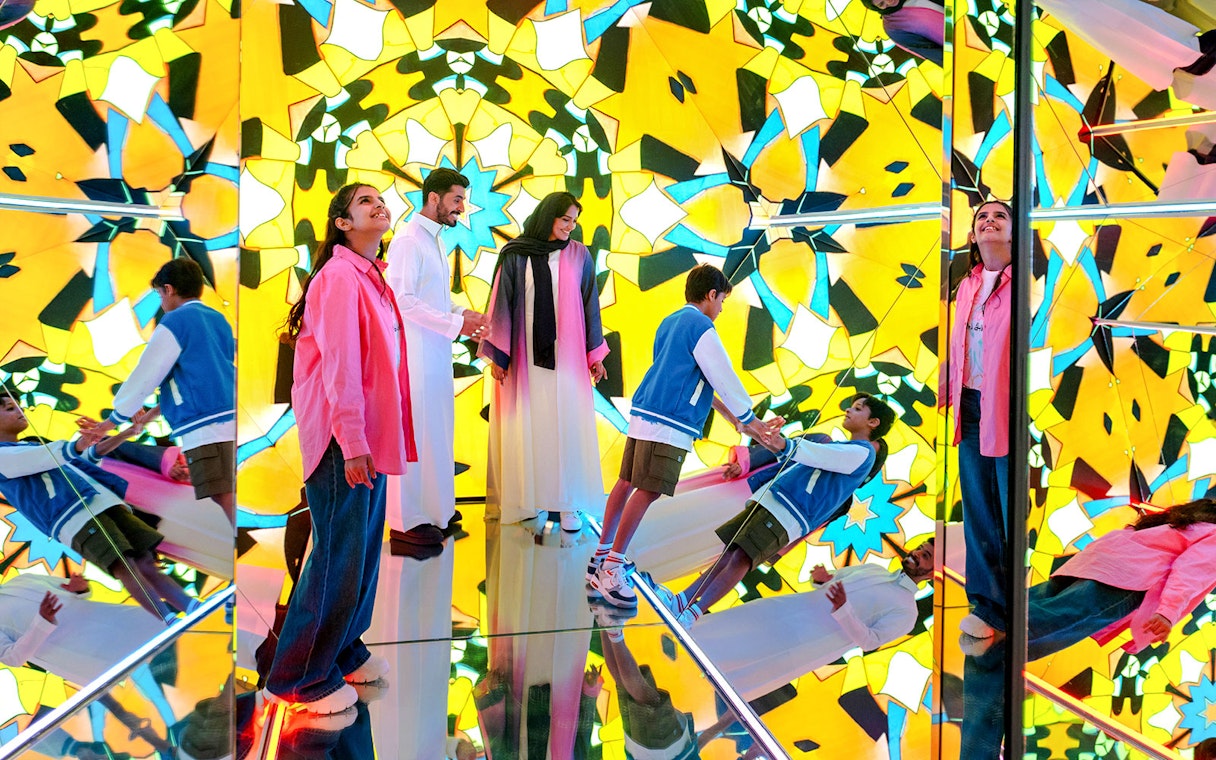 Visitors exploring mirrored kaleidoscope room at House of Hype.